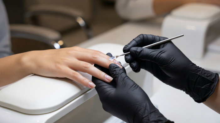 Professional manicurist delicately performing nail care on client hand